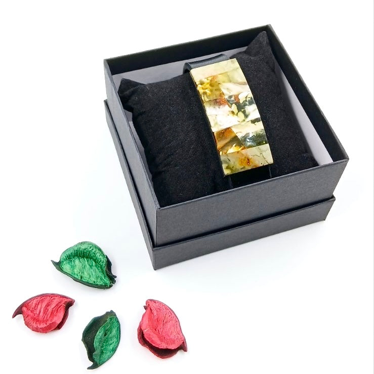 Close-up of handcrafted leather bracelet showcasing unique design with green and white amber stone