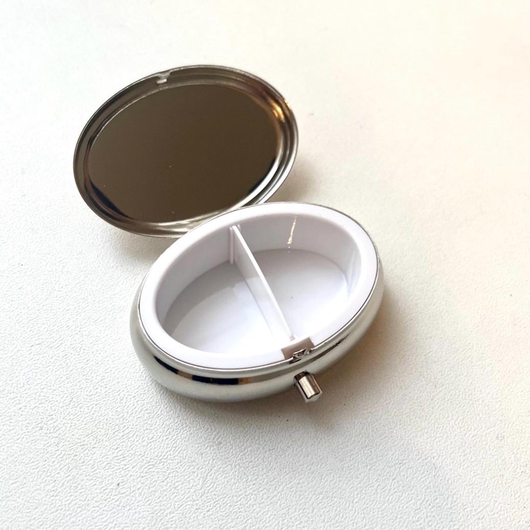 Small oval pill case with natural Baltic amber and metal construction