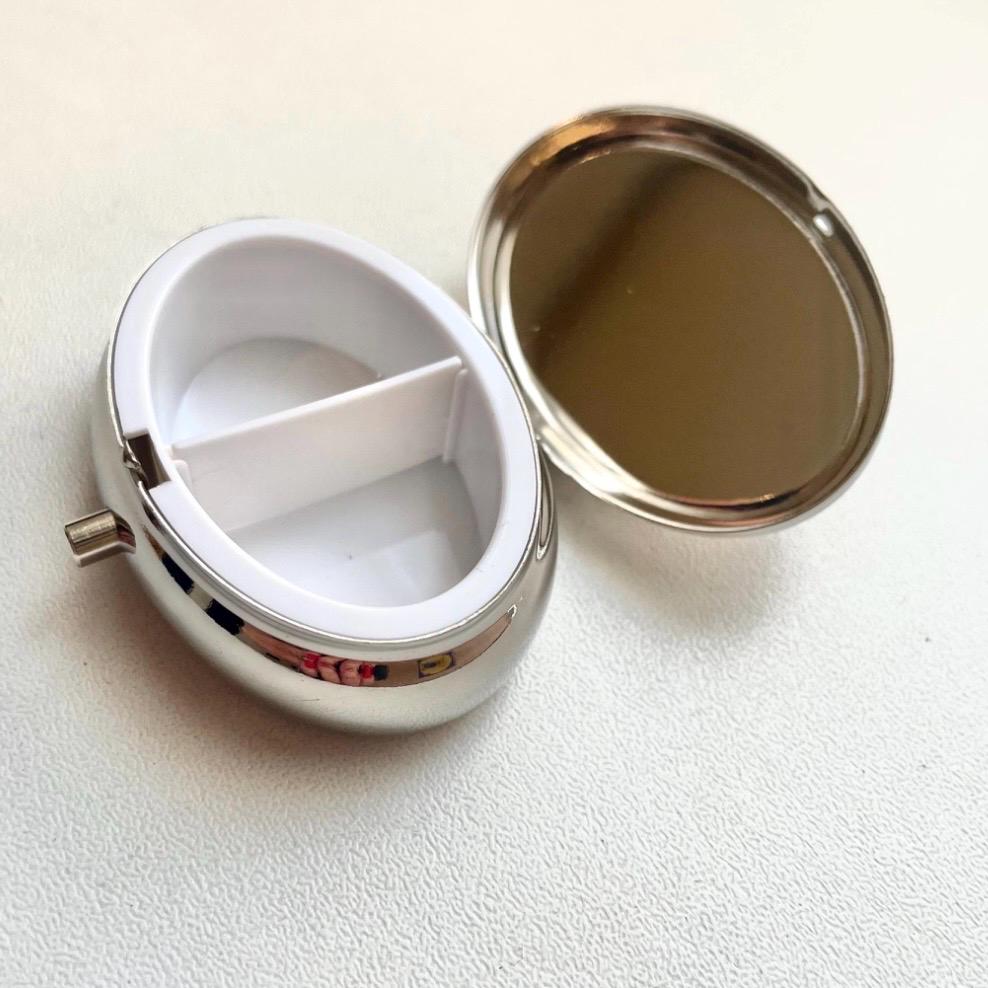 Elegant oval pillbox featuring genuine Baltic amber and stainless steel