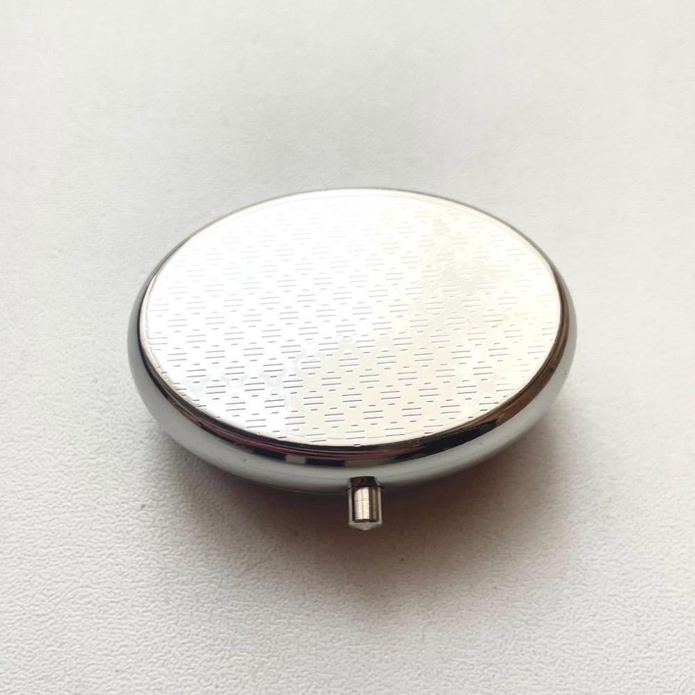Elegant oval pillbox featuring genuine Baltic amber and stainless steel