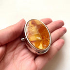 Oval stainless steel pillbox decorated with natural milky Baltic amber mosaic
