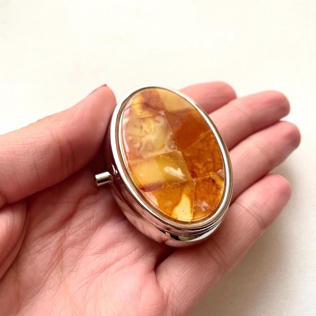 Oval stainless steel pillbox decorated with natural milky Baltic amber mosaic