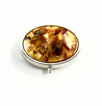 Handmade oval pill case featuring old milky Baltic amber and steel body