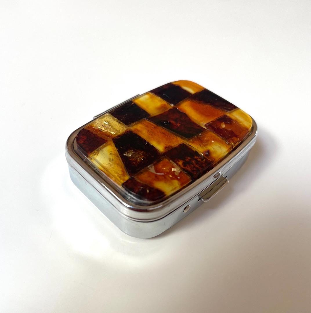Small stainless steel pillbox decorated with natural Baltic amber mosaic, portable medicine container.