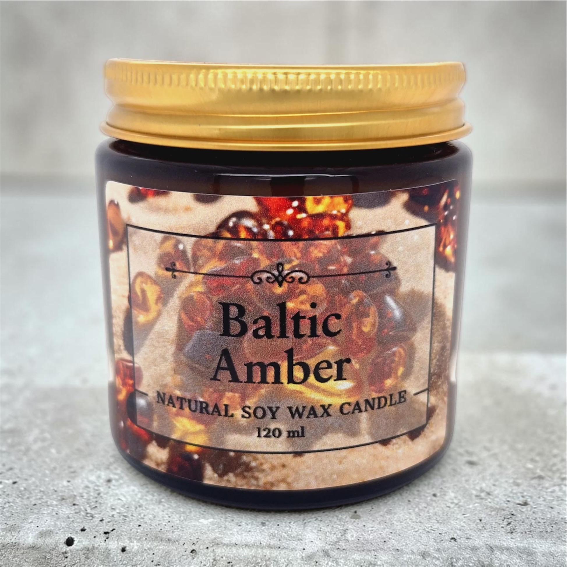 Natural soy wax candle with Baltic Amber fragrance, decorated with genuine Baltic amber stones in an elegant amber glass container.