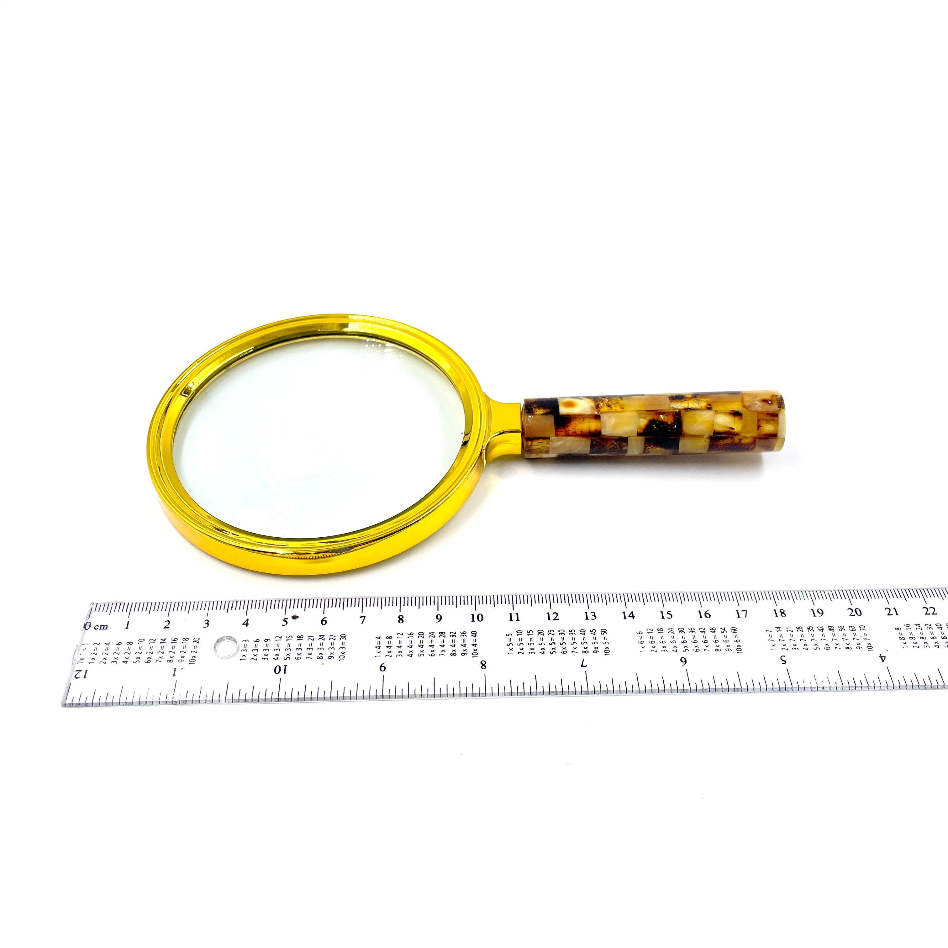magnifying glass big one for book reading near ruler decorated with light amber